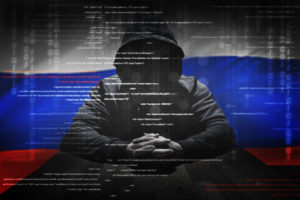 Concept hacker at work with Russian flag on background