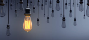 Glowing Light Bulb Standing Out From the Crowd