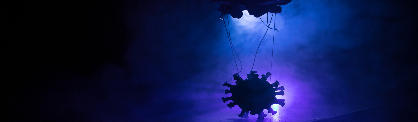 Coronavirus 2019-nCov novel coronavirus concept. Crowd looking on big Corona virus model at night with fog and backlight. Creative artwork decoration. Selective focus.